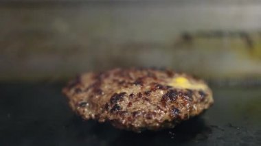 Fast food restoranında et kızartılıyor. Hamburger yemeği için hazırlanmış domuz pirzolasının video dudağını kapatın. Lokantada büyük bir parça köfte kızartılıyor.