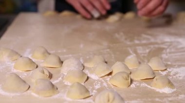 Aşçı restoran mutfağında geleneksel İtalyan etli ravioli ve beyaz un ve etli börek hazırlıyor. Rus pelmeni yemek pişirme süreci yakından çekiliyor.