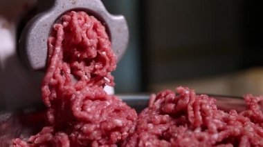 Hamburger için köfteye çiğ et doğrayan kıyma makinesi. Hamburgerler için sağlıklı, doğal gıda malzemeleri. Izgara için kıyma doğrayan biftek. Kasapta biftek doğrayan öğütücü.