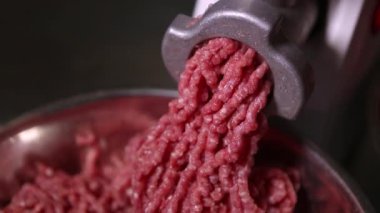 Hamburger için köfteye çiğ et doğrayan kıyma makinesi. Hamburgerler için sağlıklı, doğal gıda malzemeleri. Izgara için kıyma doğrayan biftek. Kasapta biftek doğrayan öğütücü.