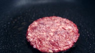 Akşam yemeği için fast food mutfağında sıcak tavada taze kırmızı et köftesi. Geleneksel Amerikan fast food burgeri yakın çekim video klibinde pişiyor. Hamburger için kızarmış domuz pirzolası.