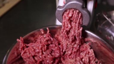 Hamburger için köfteye çiğ et doğrayan kıyma makinesi. Hamburgerler için sağlıklı, doğal gıda malzemeleri. Izgara için kıyma doğrayan biftek. Kasapta biftek doğrayan öğütücü. 