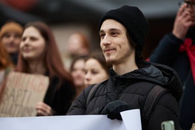 Barışçıl bir gösteride neşeli, genç bir Ukraynalı 'nın portresi. Ukrayna 'da halk mitingi. Halk askeri bütçenin artırılmasını talep ediyor. Kyiv - 24 Şubat 2024