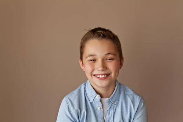 Sorria Menino Bonito Uma Camisa Azul Fica Fundo Bege — Fotografia de Stock