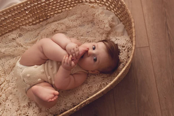 彼女の脚とウィンドウと再生の横にある籐のバスケットは ヶ月の女児 — ストック写真