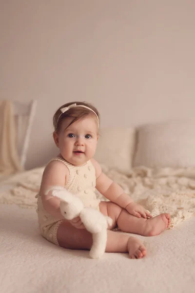 おもちゃが付いているベッドの上に座って ヶ月の女の子の肖像画 — ストック写真