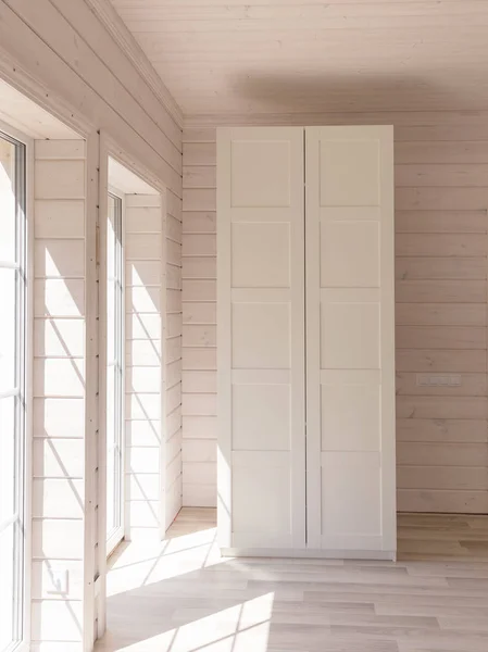 Σκανδιναβικό στυλ διαμερίσματα. Φως υπνοδωμάτιο εσωτερικό σε ένα οργανικό ξύλινο σπίτι λευκού χρώματος. Έπιπλα ΙΚΕΑ, ντουλάπα. Ξύλινο πάτωμα, πέτρινοι τοίχοι, ξύλινο ταβάνι. Ντουλάπι λευκό. Παράθυρα με πανοραμική θέα — Φωτογραφία Αρχείου