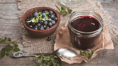 Böğürtlenli reçel çilek ve yaprakları rustik ahşap masa üzerinde kavanoza