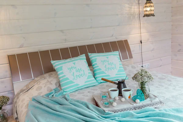 A cozy bedroom with coffee cups, wildflowers on a wooden board in bed at home. Romantic breakfast, rest, relaxation, love. Wooden house — Stock Photo, Image