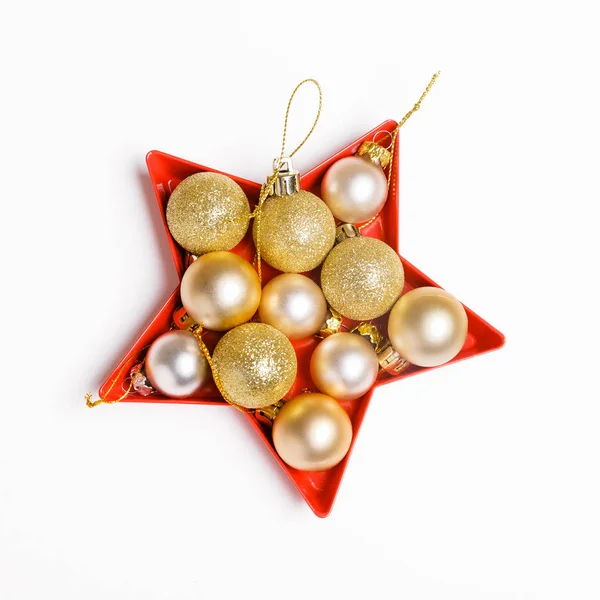 Σύνθεση διακοπών Χριστουγέννων. Εορταστική Χριστουγεννιάτικη χρυσή μπάλες που ορίζονται στο σχήμα του ένα αστέρι σε λευκό φόντο. — Φωτογραφία Αρχείου