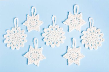 Noel bileşimi dantelli beyaz kar taneleri ve mavi arka plan üzerinde yıldız. Üstten görünüm, düz yatıyordu, kopya alanı.