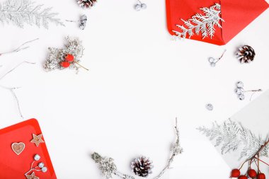 Noel kompozisyonu. Hediyeler, köknar ağacı dalları, beyaz arka planda kırmızı süslemeler. Noel, kış, yeni yıl konsepti. Düz konum, üst görünüm, kopyalama alanı