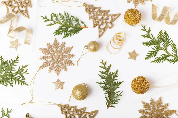 Composición navideña. Patrón de oro creativo festivo, bola de Navidad de decoración de oro de Navidad con cinta, copos de nieve, árbol de Navidad sobre fondo blanco . — Foto de Stock
