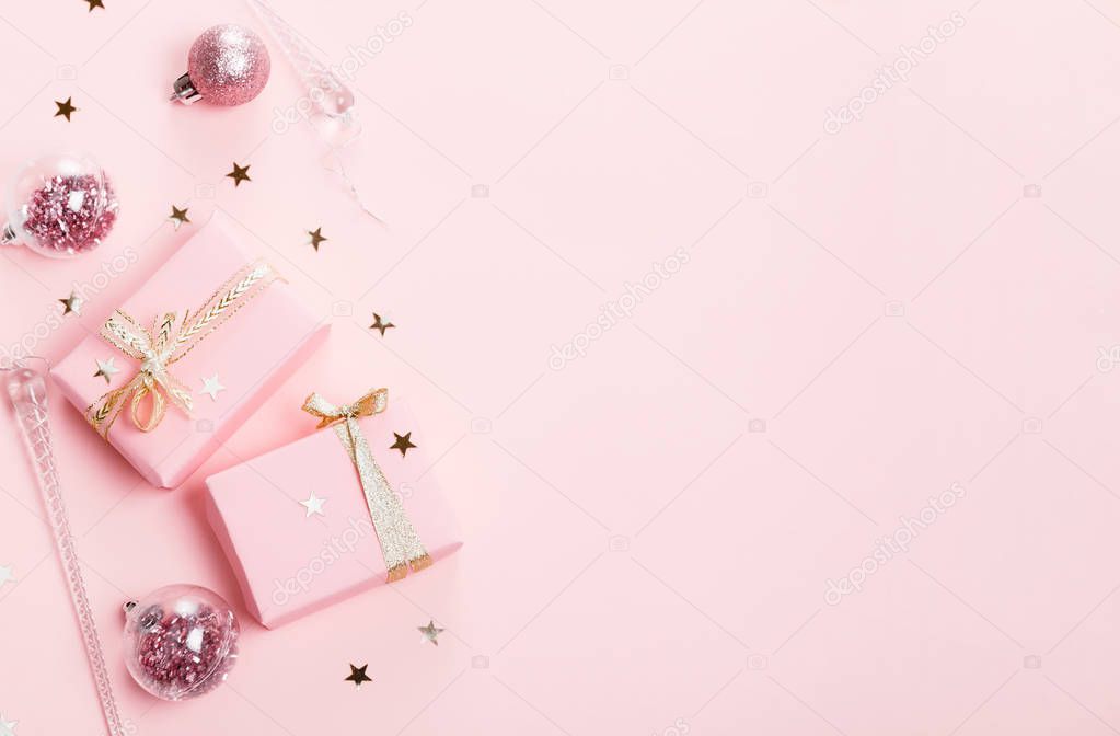 Christmas composition. Xmas pink decor holiday ball with ribbon on pink background.