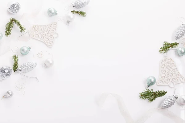 Composición navideña. Ramas de abeto, árbol de Navidad, bola de fiesta de decoración de plata de Navidad con cinta sobre fondo blanco . — Foto de Stock