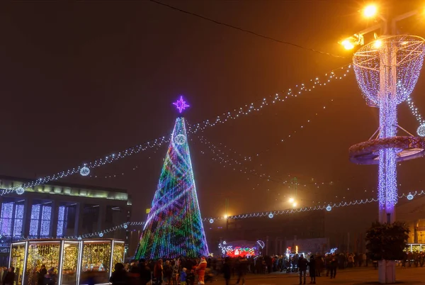 Mińsk, Białoruś - 30 grudnia 2018 r.: choinki, Iluminacje i dekoracje przed budynkiem Pałacu Republiki w placu Oktiabrskaja. — Zdjęcie stockowe