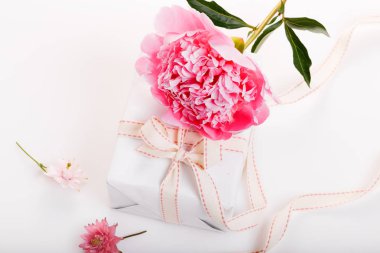 Yaprakları çiçek ve ahşap tahta üzerinde beyaz kurdele ile hassas beyaz pembe Şakayık. Ek yükü üstten görünüm, düz yatıyordu. Uzay kopyalayın. Doğum günü, anne, Sevgililer, kadın, düğün günü kavramı