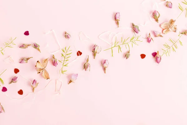 Composición de flores. Marco hecho de flores de rosas secas sobre fondo rosa . — Foto de Stock
