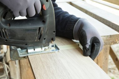 İnşaat konseptinde laminat parke döşenen adam. İnşaat, onarım konsepti.