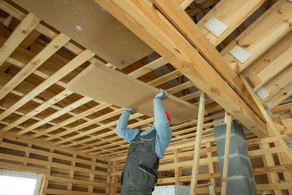 Obrero de la construcción aislante térmicamente eco casa marco de madera — Foto de Stock