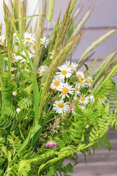 A bouquet of summer wild herbs and flowers in nature, the summer solstice. Summer sun celebration