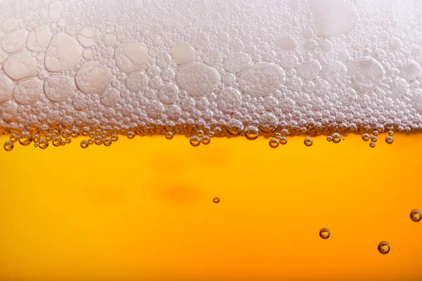 Наливание пива с пеной пузыря в стекле для заднего плана — стоковое фото