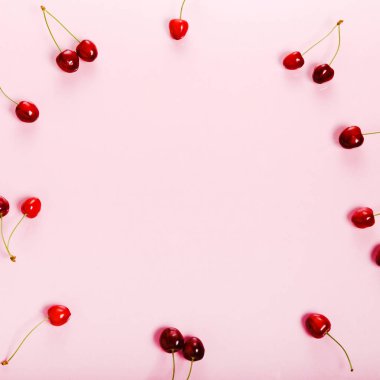 Tropikal yaz soyut arka plan. Pembe arka planda kesimler ve yapraklar ile Kiraz kiraz.