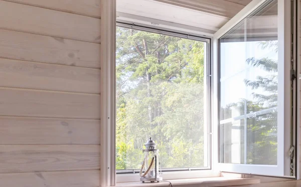 Białe okno z moskitierą w rustykalnym drewnianym domu z widokiem na ogród, płytkie głębia ostrości — Zdjęcie stockowe