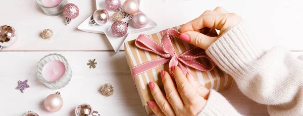 Preparación de regalos de Navidad en una mesa de madera blanca con decoraciones rosadas — Foto de Stock