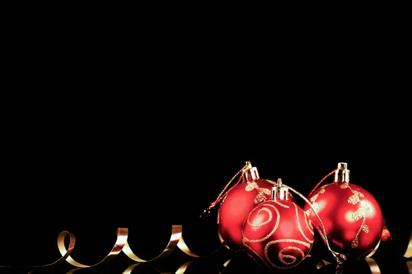 Siyah arka planda altın kurdeleli Noel kırmızı topu — Stok fotoğraf