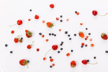 Taze yaz meyveleri, çilekler, ahududular, yabanmersinleri, beyaz arka planda kirazlar