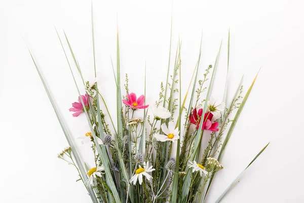 Bouquet festif de rose et violet, fleurs sauvages blanches, cosmétiques, herbes sur fond blanc — Photo