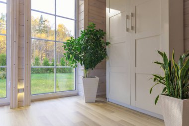 Büyük pencereli, yüksek tavanlı, beyaz ahşap zeminli parlak fotoğraf stüdyosu.