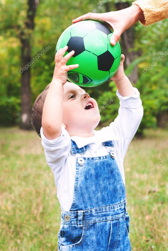 Child boy plays football with parents - healthy active lifestyle