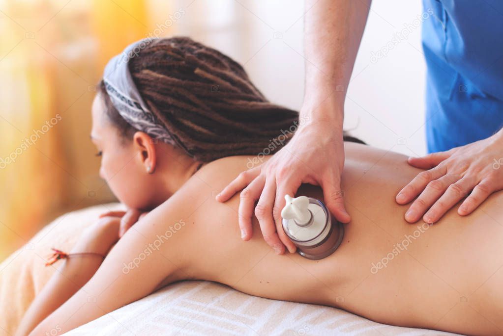 Close-up of masseur hands doing back massage - Healing Massage and body care - young woman getting spa massage treatment at beauty spa salon