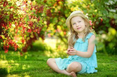 Sevimli küçük kız kırmızı kuş üzümü bir bahçede sıcak ve güneşli yaz gününde malzeme çekme. Küçük çocuklar için taze sağlıklı organik gıda. Yaz aylarında Aile aktiviteleri.