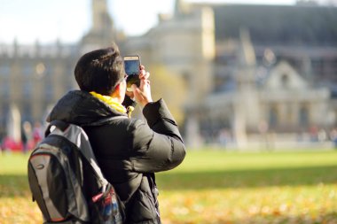 Londra, İngiltere - 19 Kasım 2017: onun cep telefonu ile fotoğraf çekme genç erkek turist. Büyük Britanya'nın başkentinde güzel güneşli bir sonbahar gün.