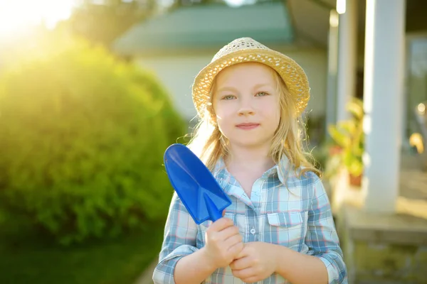 可爱的小女孩戴着草帽 在阳光明媚的夏日里手持玩具花园工具 小孩子的园艺活动 — 图库照片