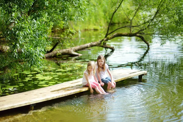 Duas Meninas Bonitinhas Sentadas Uma Plataforma Madeira Junto Rio Lago — Fotografia de Stock