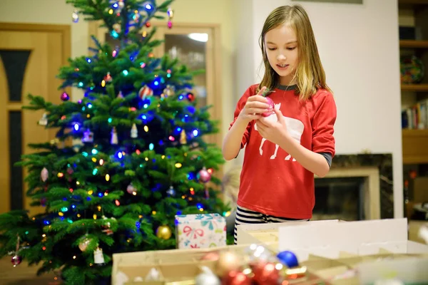 Urocza Dziewczynka Dekorująca Choinkę Kolorowymi Szklanymi Bombkami Przycinam Choinkę Świętowanie — Zdjęcie stockowe