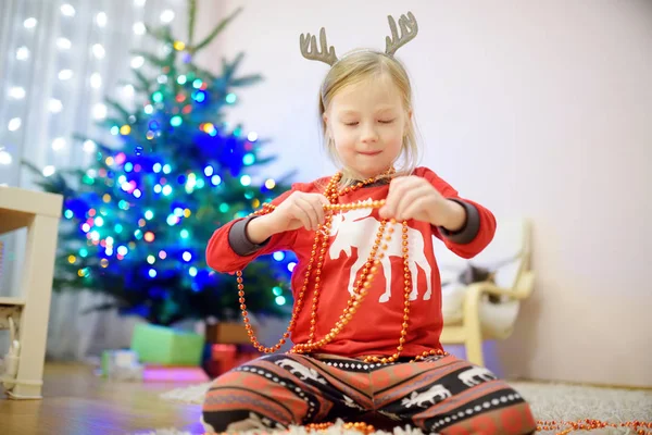 カラフルなガラスの泡でクリスマスツリーを飾る愛らしい少女 クリスマスツリーをトリミングします 自宅でクリスマスを祝う — ストック写真