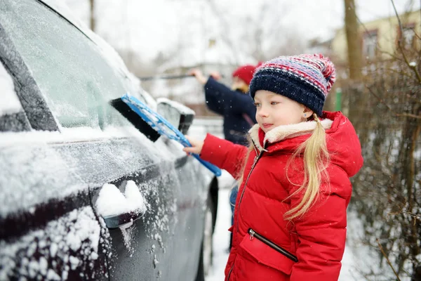 一个可爱的小女孩 帮助从汽车刷雪 妈咪的小帮手儿童冬季活动 — 图库照片