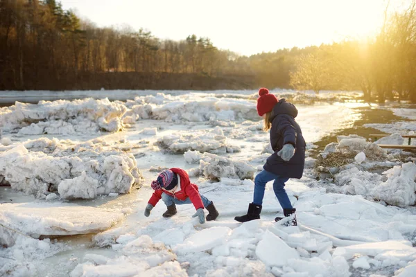 氷休憩中に凍った川で氷のブロックで遊んで幸せな姉妹 冬の楽しい様子 子供のための冬のアクティビティ — ストック写真