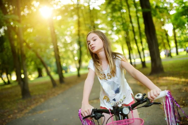 日当たりの良い夏の日に公園で自転車に乗ってかわいい女の子 子供と一緒に家族レジャー — ストック写真