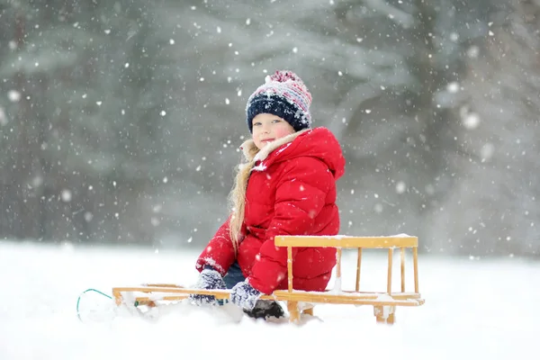 美しい冬の公園でそりを楽しんで面白い女の子 かわいい子は 雪で遊ぶ 子供のための冬のアクティビティ — ストック写真