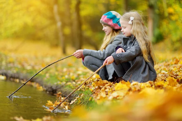 かわいい女の子が美しい秋の日の水で遊ぶ 秋の公園で楽しい幸せな様子 子供のための秋の活動 — ストック写真