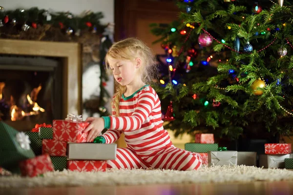Fröhliches Kleines Mädchen Weihnachtlichem Pyjama Kamin Einem Gemütlichen Dunklen Wohnzimmer — Stockfoto