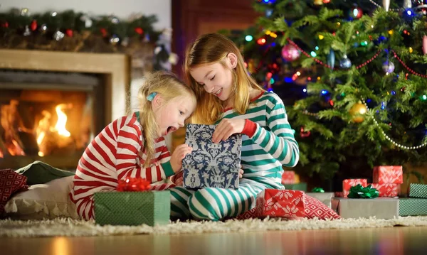 Fröhliche Kleine Schwestern Weihnachtlichem Schlafanzug Öffnen Heiligabend Geschenkboxen Kamin Einem — Stockfoto