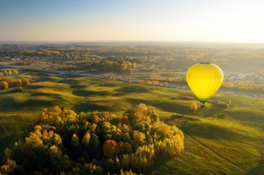 Güneşli bir sonbahar akşamı Vilnius Şehri çevreleyen ormanlar üzerinde uçan renkli sıcak hava balonu. Vilnius burada sıcak hava balonları uçmak için izin verilen kaç Avrupa sermaye kentlerinden biridir.