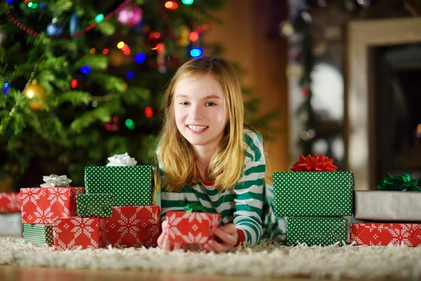 快乐的小女孩穿着圣诞睡衣在舒适的黑暗客厅里在壁炉旁玩耍 — 图库照片